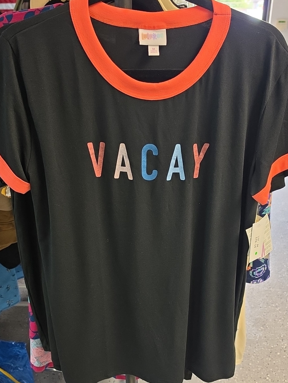LuLaRoe Black Tee with Orange Trim and Multicolor VACAY Letters